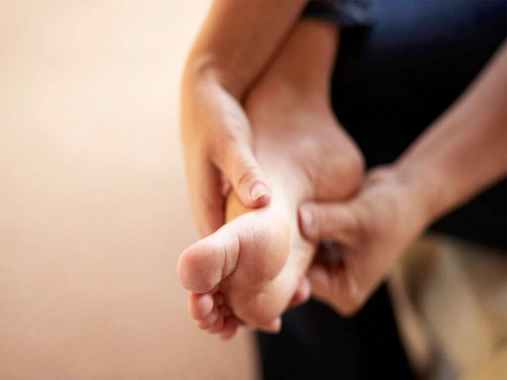 A person touching their foot while sitting
