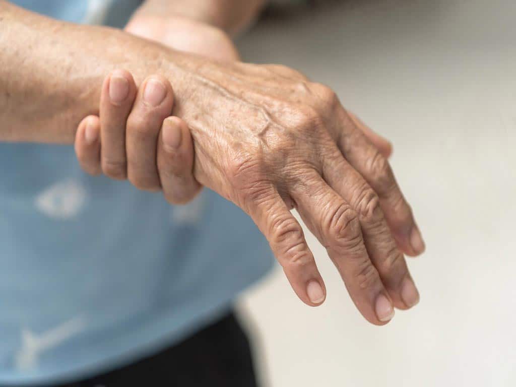 A person holding his aching hand