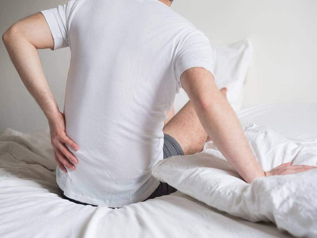 Man with lower back pain upon waking up
