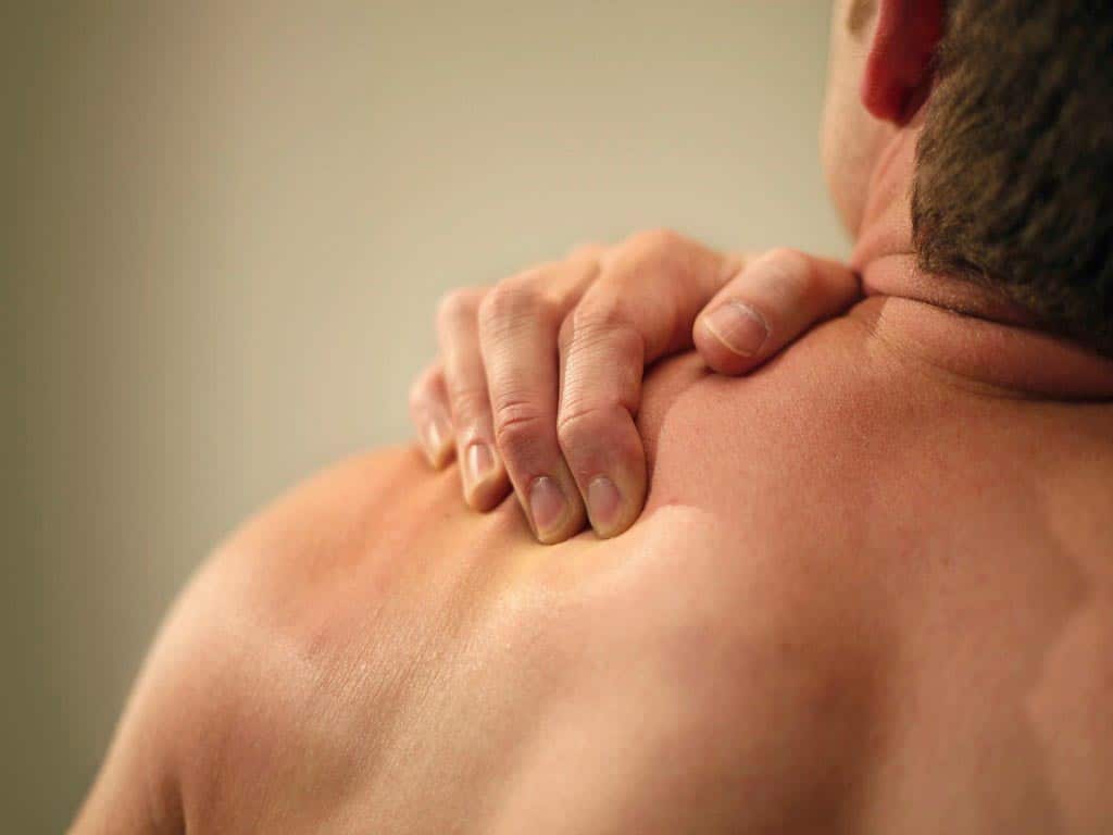 Man pressing the muscles on his shoulder