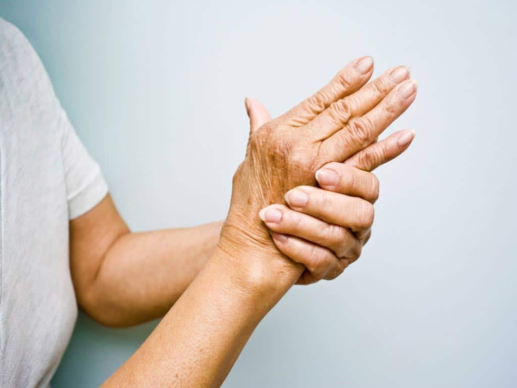 A person holding their aching hand