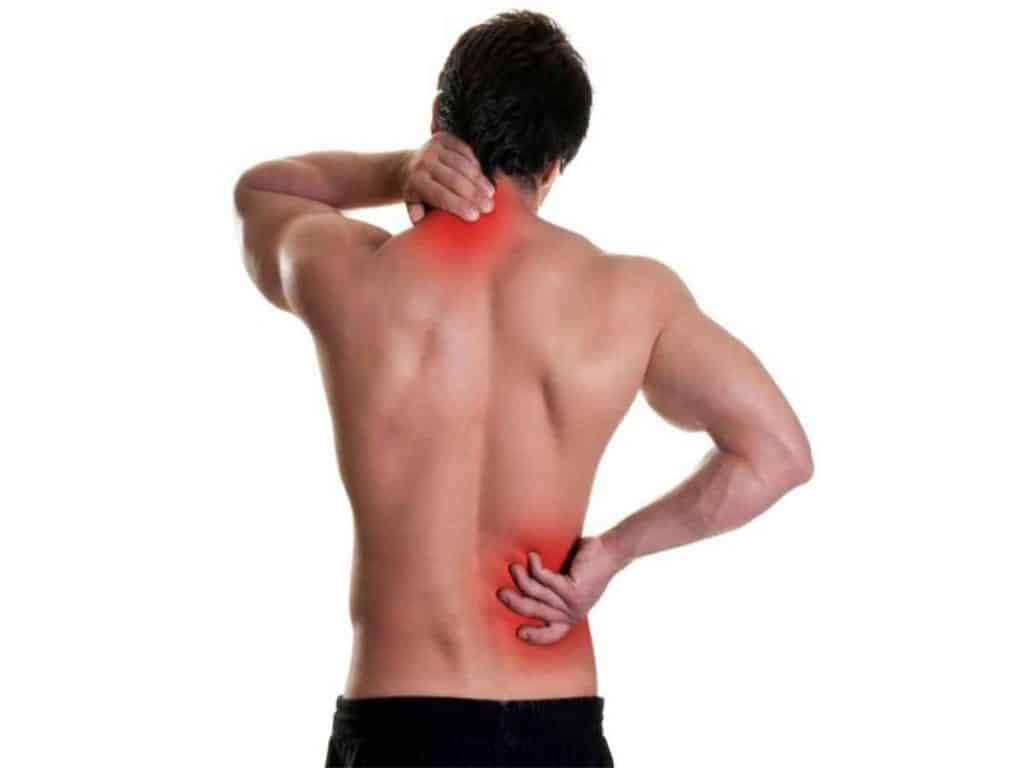 A shirtless man holding his nape and lower back due to pain