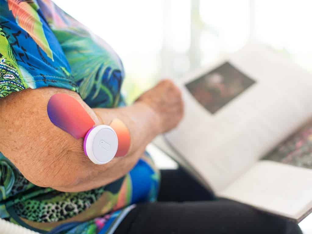 An elderly woman using an iTENS electrode on her arm