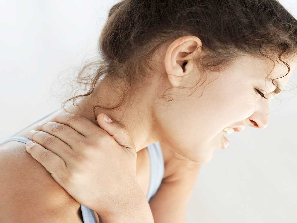 A woman touching the side of her neck