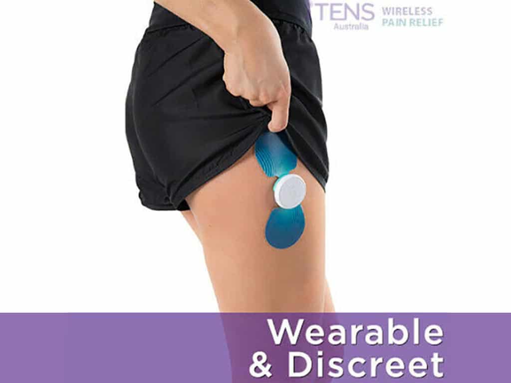 A person using a wearable and discreet iTENS on her thigh