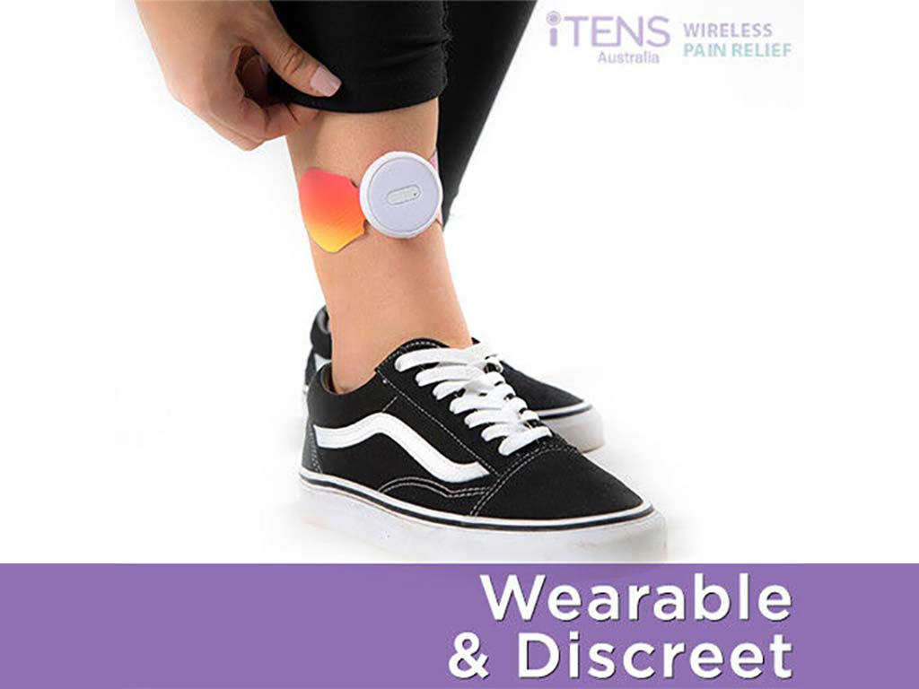 A person using iTENS discreetly on her shin
