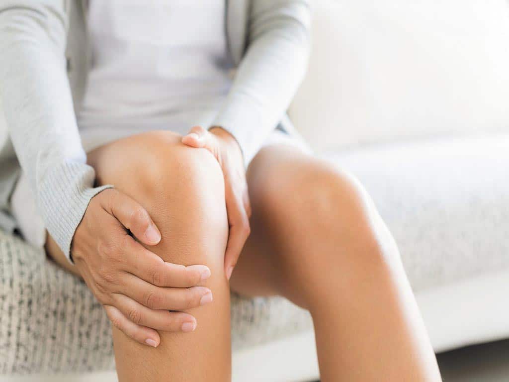 A person holding her knee due to pain