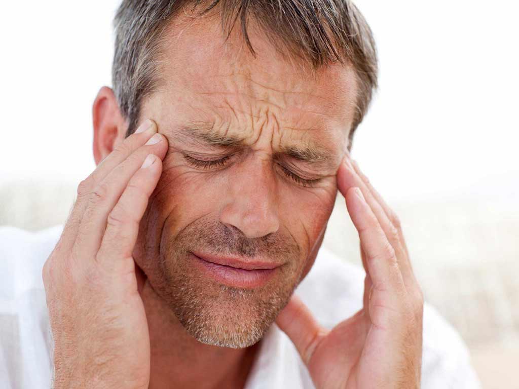 Man pressing his temples because of headache